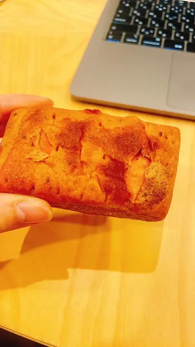 ベースブレッドいちご味を片手で持ってPCの前で撮った写真